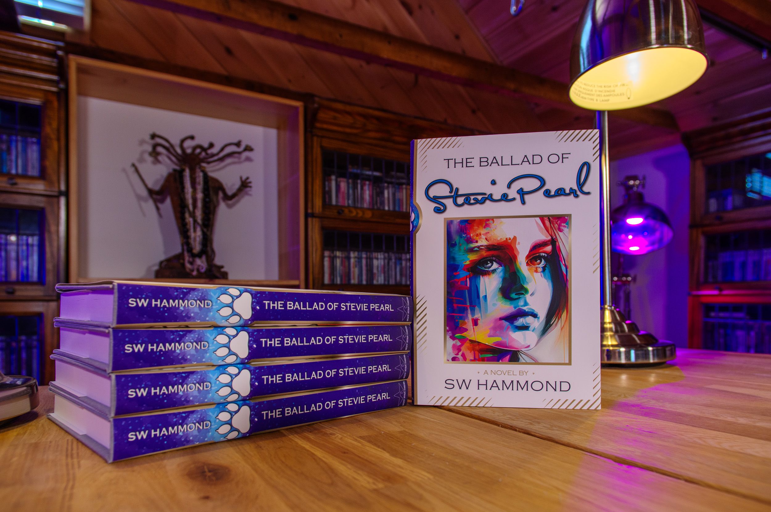Photograph of the hardcover version of The Ballad of Stevie Pearl. A stack of books and the cover.